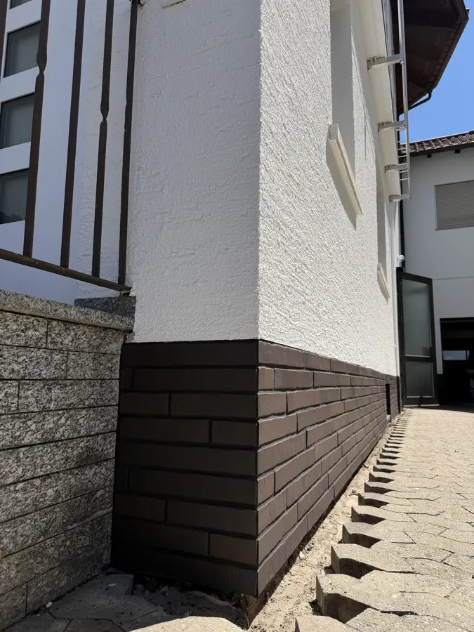 Hauswand-Sockel mit dunklen Riemchen